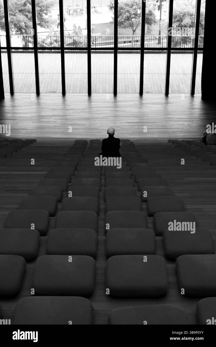 Una figura solitaria siede nell'auditorium M+ Museum Foto Stock