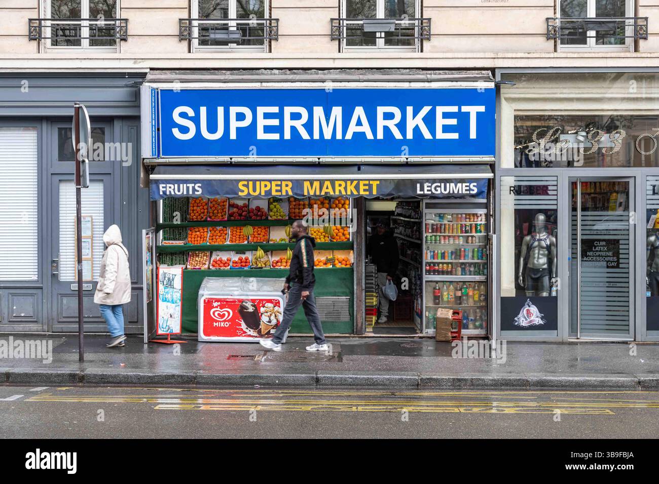 Passanti di fronte al supermercato 33 al 33 di Boulevard de Clichy nel quartiere Montmartre di Parigi, Francia Foto Stock