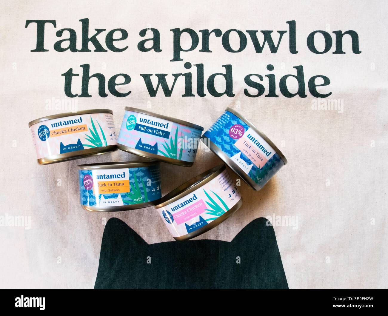 Scatolette riciclabili intere di carne fresca e pesce prodotti alimentari sani per gatti su una borsa di tela promozionale dalla società britannica online Londra Regno Unito Foto Stock