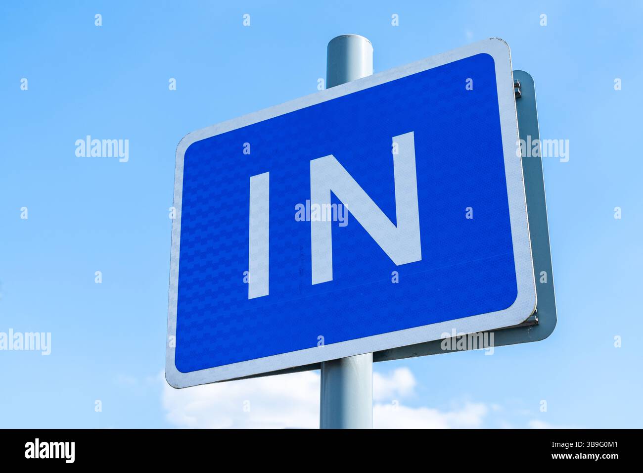 Cartello "in", segnale stradale del Regno Unito in un quadrato blu con consigli o indicazioni sulla direzione Foto Stock