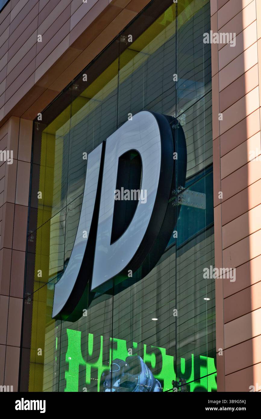 Foto esterna di un edificio con un grande logo "JD" montato su una facciata della finestra. L'edificio presenta esterni piastrellati e una parete di vetro a Liverpool, Regno Unito. Foto Stock