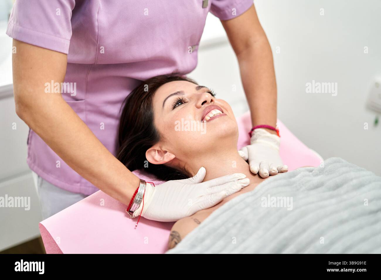 Un professionista esperto gestisce un trattamento rilassante per la cura della pelle in un salone di bellezza, migliorando il relax e il benessere durante una sessione tranquilla. Clien Foto Stock