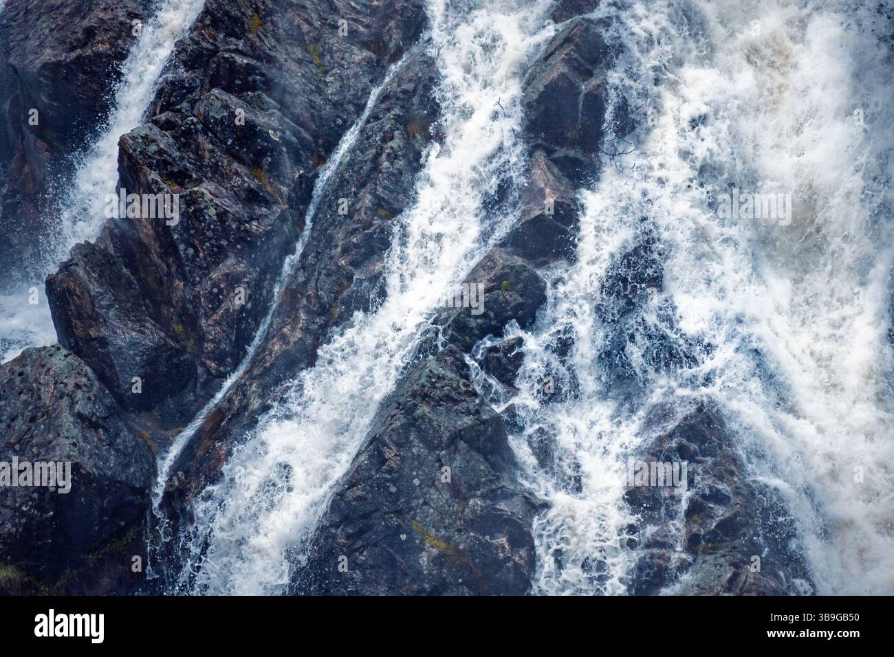 Vista dettagliata dell'acqua che cade sulle superfici rocciose a presa del Villar, Madrid, catturando la sfocatura del movimento dell'acqua che scorre. Foto Stock