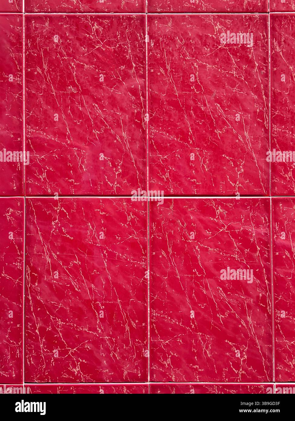 Vista ravvicinata delle piastrelle di marmo rosso intenso con un motivo a venatura naturale. I colori vibranti e le linee distintive creano un ambiente lussuoso ed elegante Foto Stock