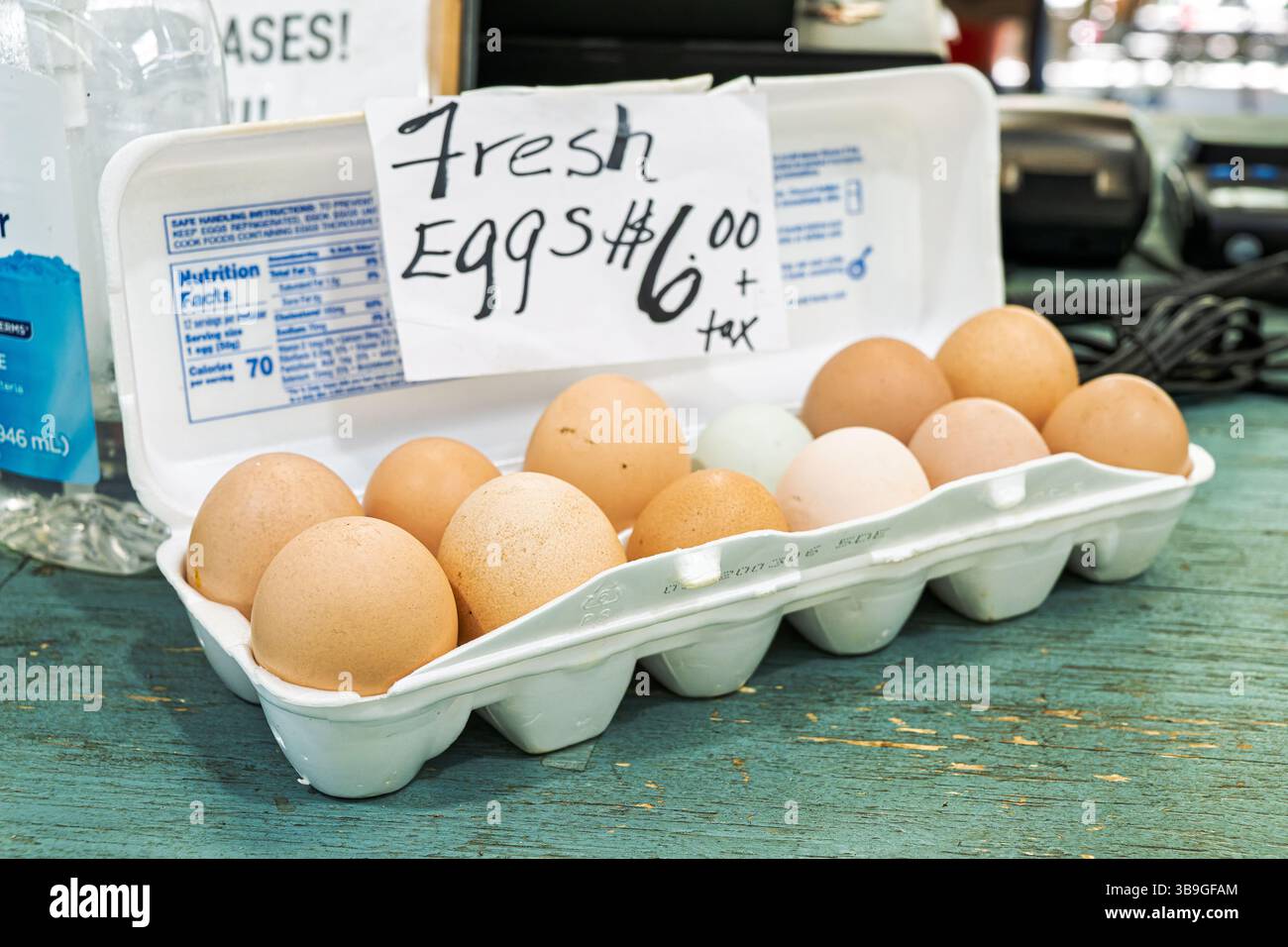 Dozzine di uova brune fresche di fattoria con un piccolo uovo azzurro in vendita al mercato agricolo locale di Montgomery, Alabama, USA. Foto Stock