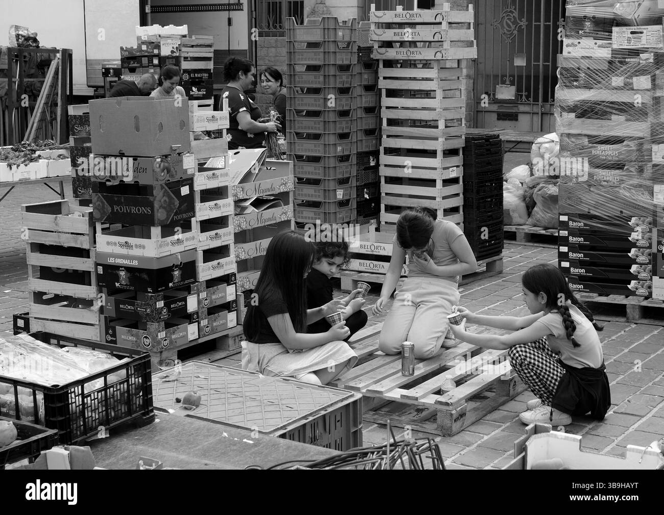 Bambini che giocano mentre i genitori lavorano al mercato di St Omer, Francia, 2025 Foto Stock