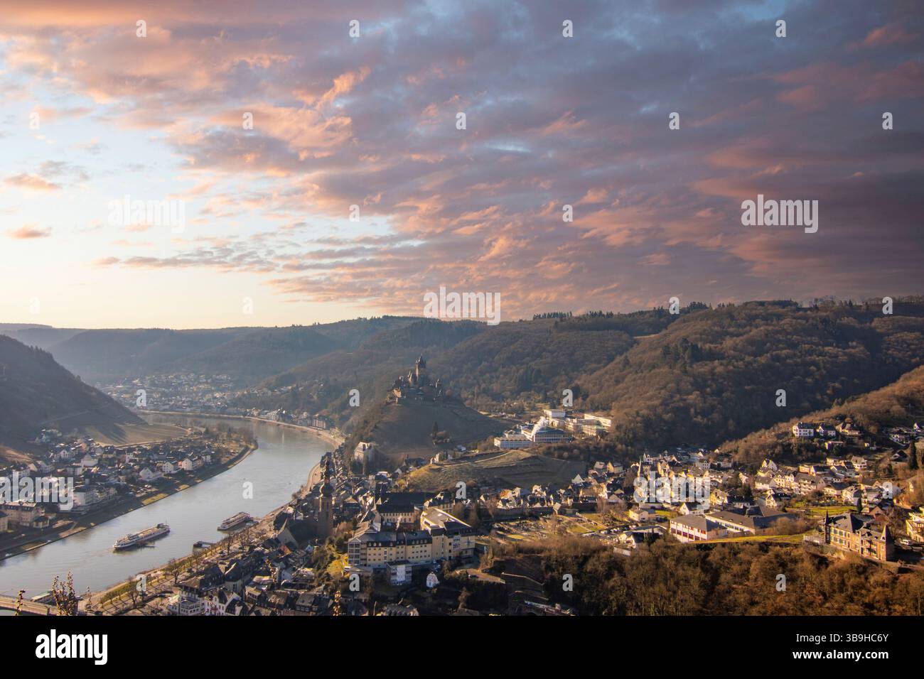 Foto di un paesaggio con vista su una città con un fiume all'alba. Freddo inverno sulla Mosella a Cochem Foto Stock