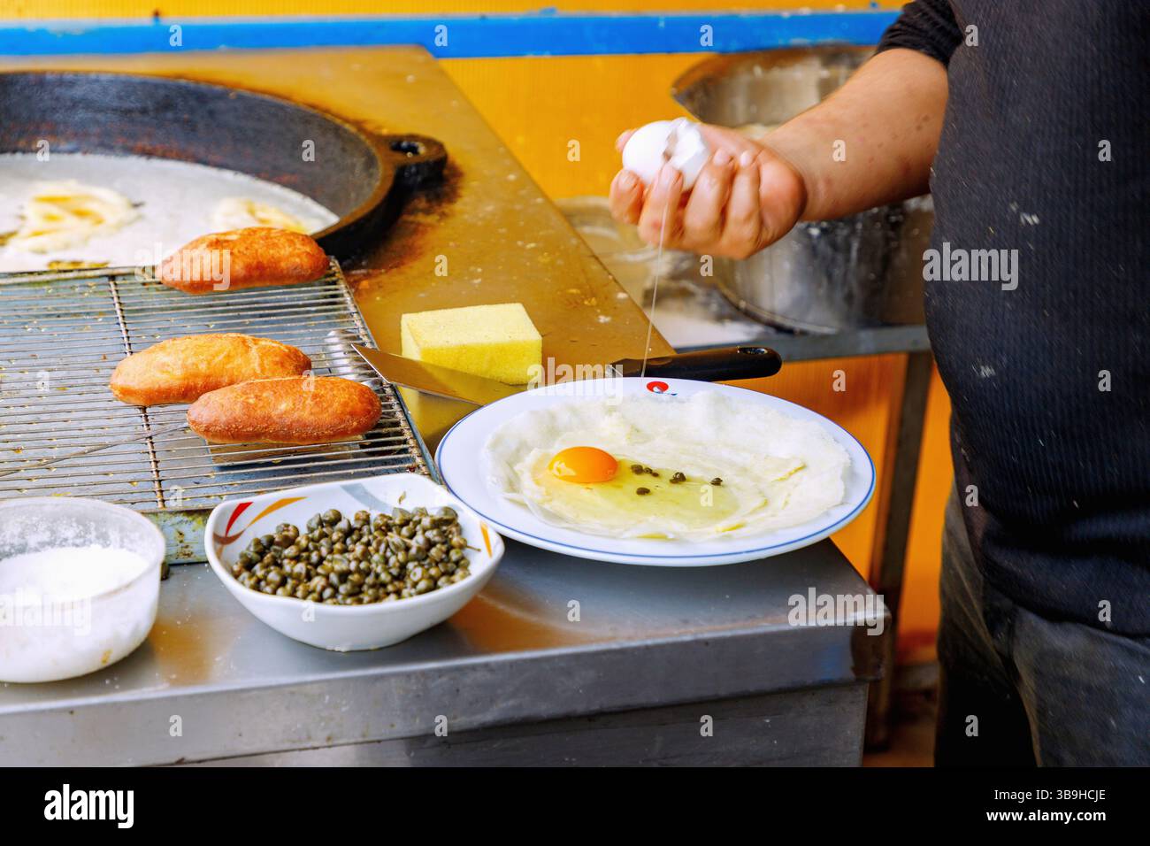 Preparazione di brik (gnocchi con purè di patate, capperi e uova) in una bancarella alimentare ad Hammamet, Tunisia Foto Stock