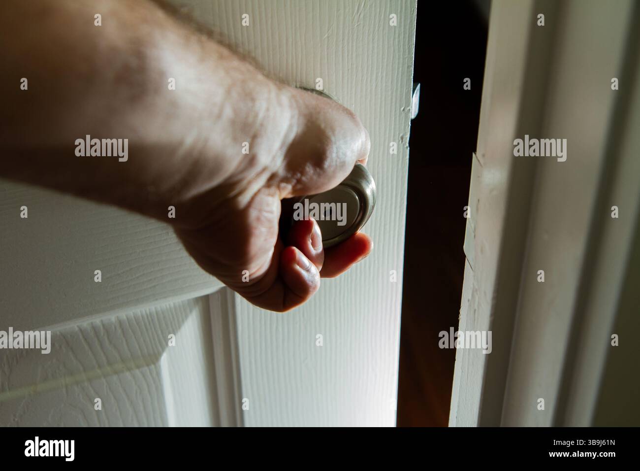Una mano tiene aperta una porta Foto Stock