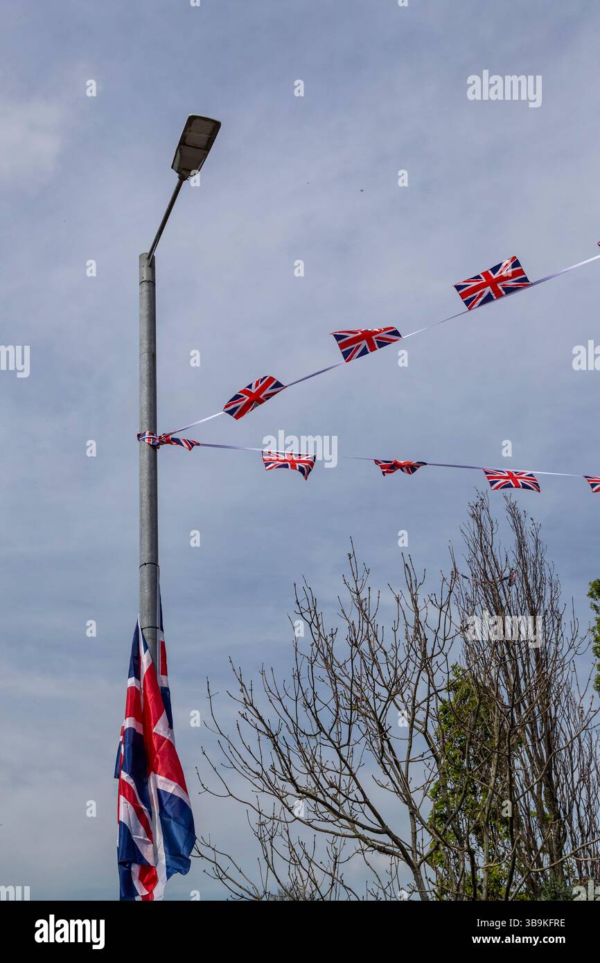 Le bandiere Union Jack volano da pali laminari in un'area protestante di Belfast. Foto Stock