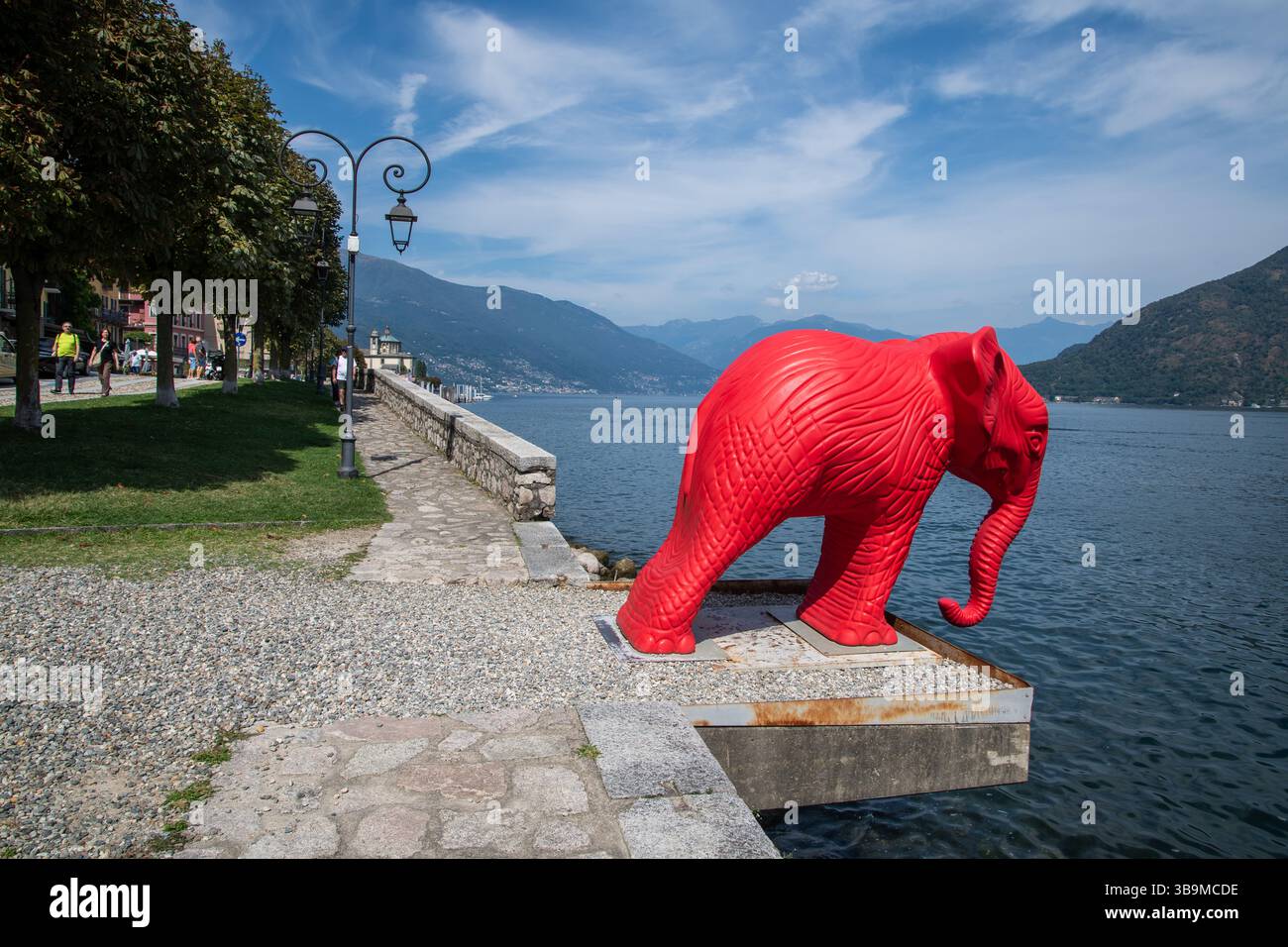 La scultura di elefante rosso si affaccia sul Lago maggiore a Cannobio, in Italia, parte di una mostra di arte animale all'aperto in tutta la città. Foto Stock