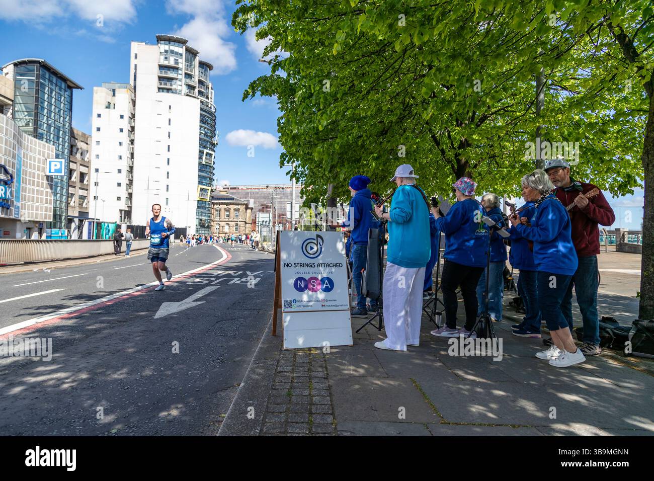 La band amatoriale Ukelele "No Strings Attached" si esibisce per i corridori e la folla alla maratona di Belfast. Foto Stock La band amatoriale Ukelele "No Strings Attached" si esibisce per i corridori e la folla alla maratona di Belfast. Foto Stock