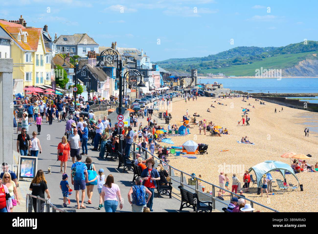 Lyme Regis, Dorset, Regno Unito. 10 maggio 2025. Meteo nel Regno Unito. I visitatori e la gente del posto si affollano nella località balneare di Lyme Regis per immergersi nel caldo sole e nell'atmosfera del festival all'evento annuale Busking Festival di B Sharp. La gente ha trascorso una giornata di attività musicali e spettacoli lungo il lungomare, mentre gli amanti della spiaggia si sono crogiolati al sole caldo sulla spiaggia. Crediti: Celia McMahon/Alamy Live News Foto Stock