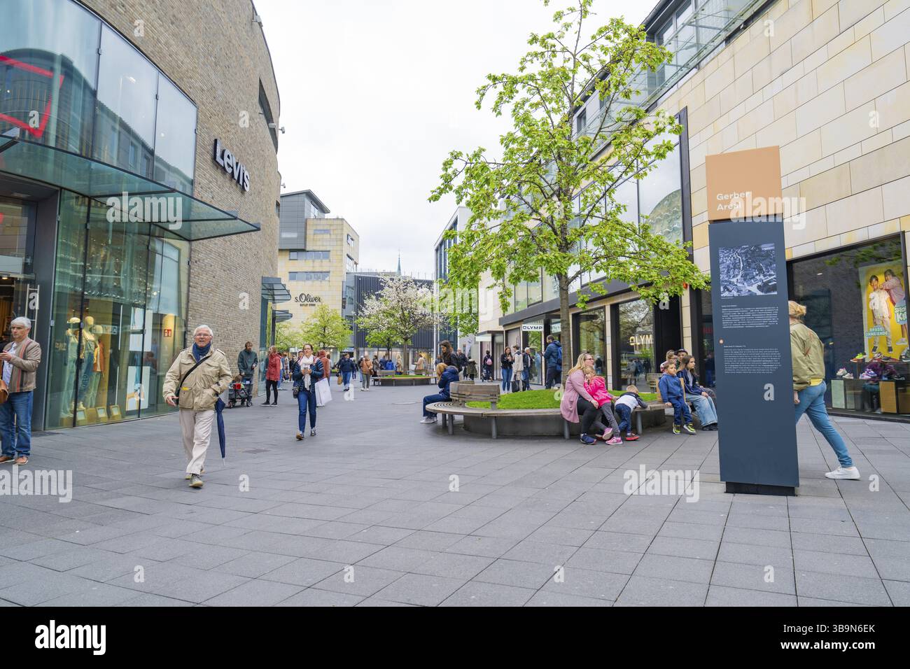 Vivace via dello shopping con negozi e persone in un ambiente urbano, Outlet City Metzingen, Germania, Europa Foto Stock