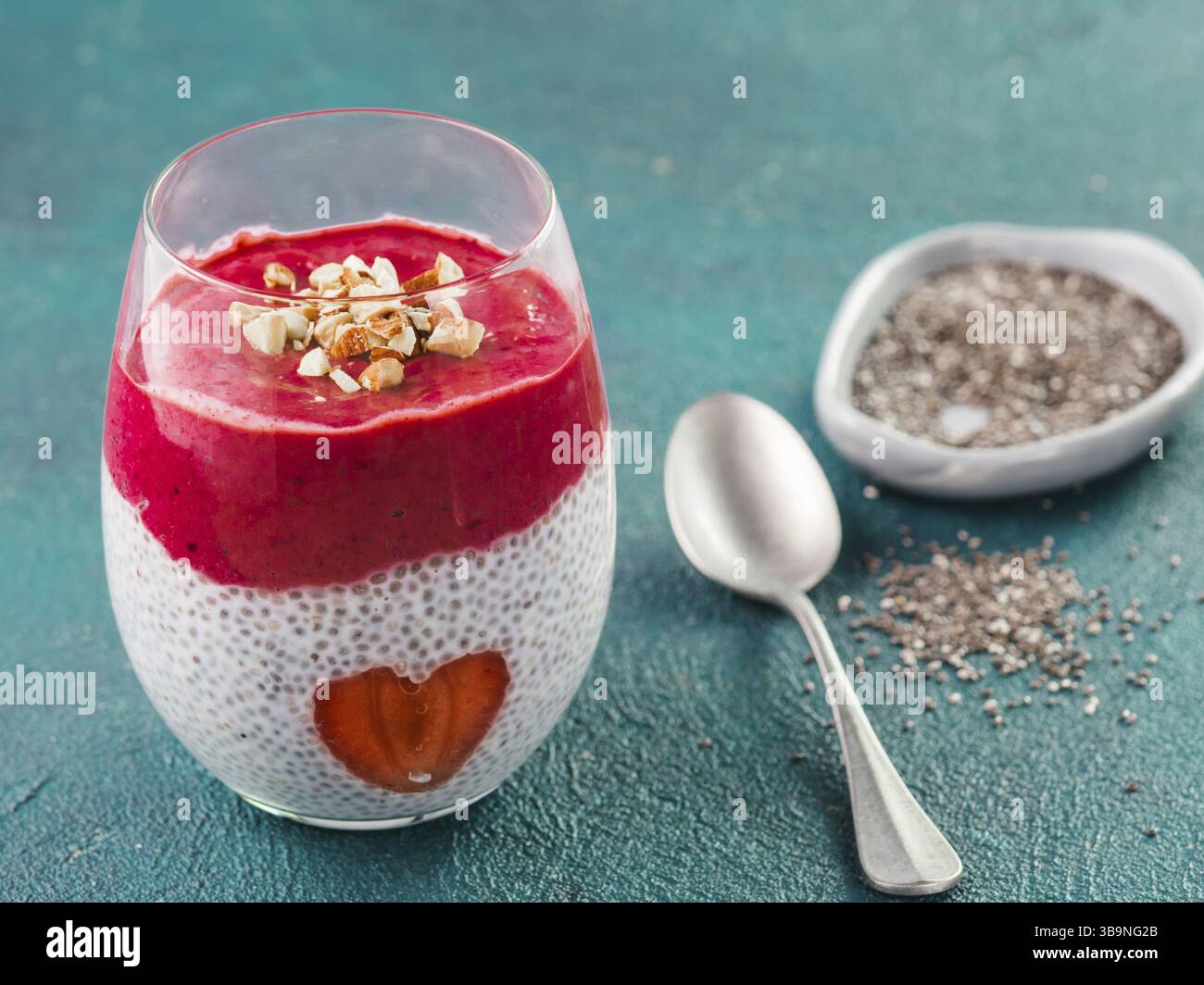 Idea per una sana prima colazione il giorno di San Valentino: Chia pudding con bacca rossa, purea di mandorle tritate sulla sommità e fragola a forma di cuore. Copia sp Foto Stock