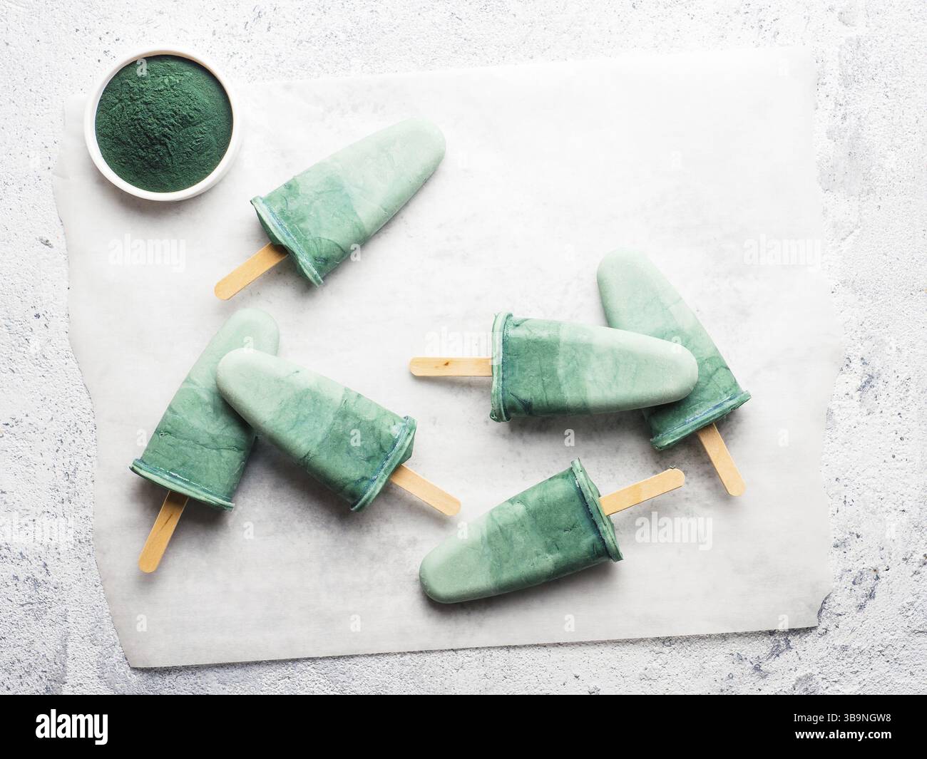 Ghiaccioli per spirulina superfood. Idee e ricette per una sana colazione, uno spuntino vegetariano estivo o un dessert vegano. Ghiacciolo con polvere di spirulina e c Foto Stock
