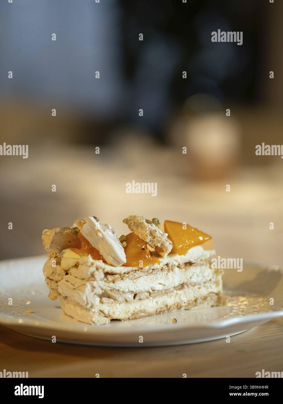 Torta sfoglia a strati con crema di formaggio cremoso, decorata con sobbri freschi. Deliziosa e accattivante fetta di torta a strati decorata con sosia arancione Foto Stock