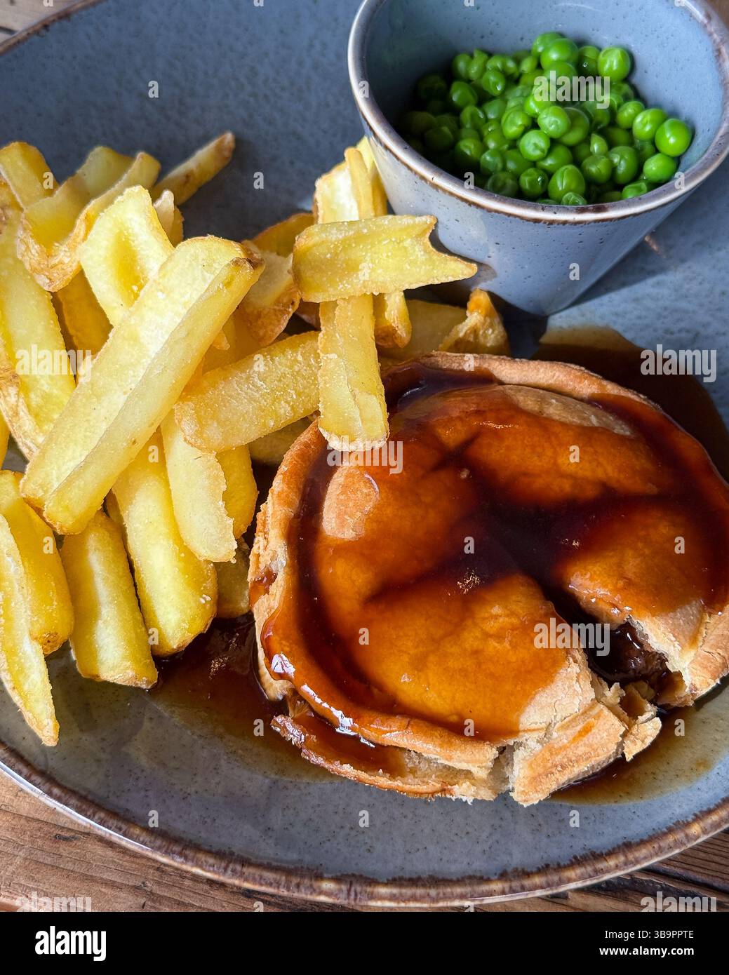 Pie chips piselli e salsa di sugo in primo piano una cena tradizionale da pub inglese Foto Stock