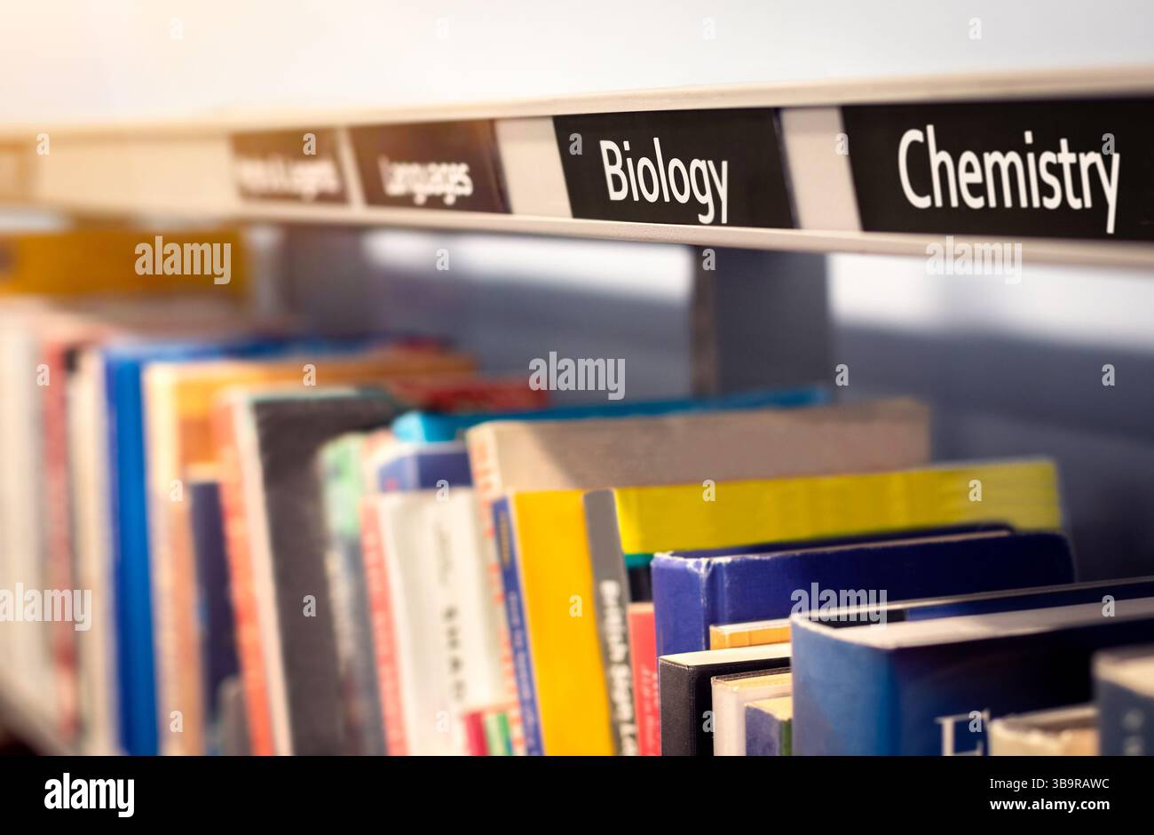 Libri impilati sugli scaffali sotto le categorie scientifiche di Biologia e chimica. Libreria di saggistica o scena di libreria che raffigura libri di riferimento fattuali. Foto Stock