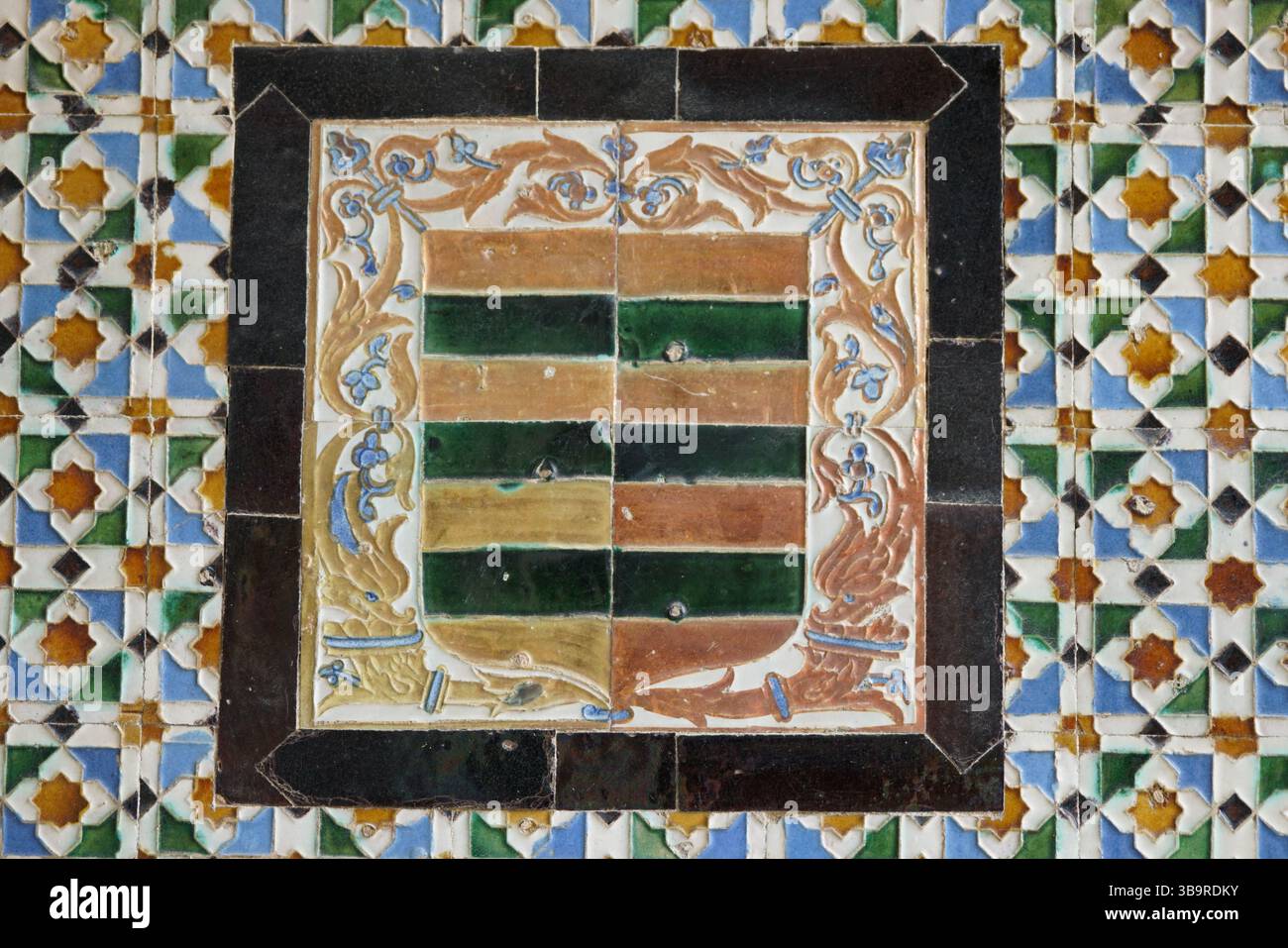 Pannello decorativo in piastrelle azulejo con uno stemma araldico e motivi floreali ornati a Siviglia, Spagna, che mostra l'artigianato tradizionale andaluso Foto Stock