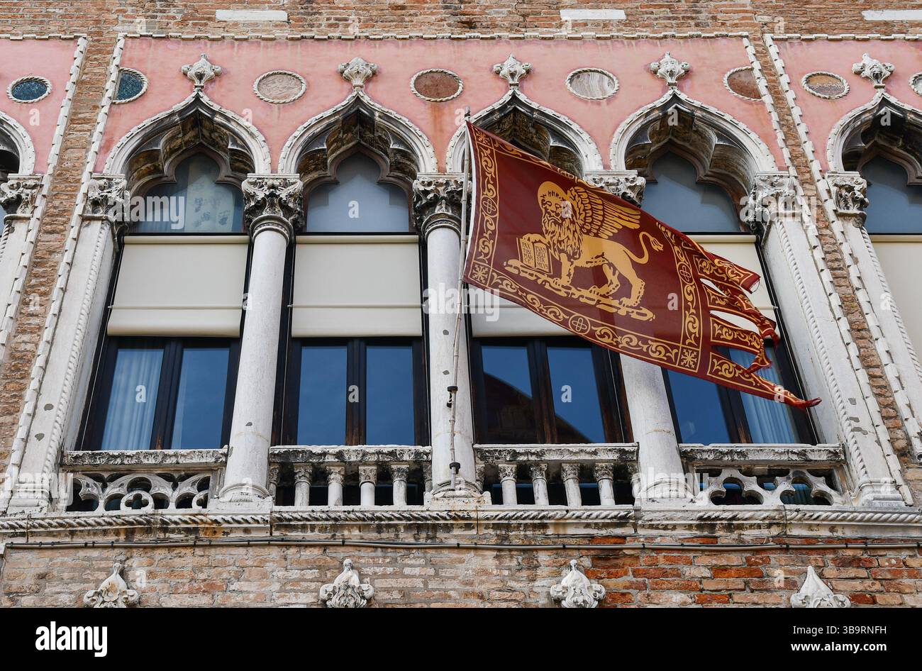 Esterno di Palazzo Gritti (XVI sec) con una finestra a quattro luci e una bandiera veneziana, in campo Sant'Angelo, Venezia, Veneto, Italia Foto Stock