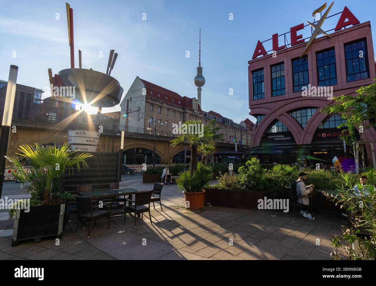 Ingresso posteriore del centro commerciale Alexa con tramonti, palme e torre della televisione di Berlino sullo sfondo, Alexanderplatz, Germania Foto Stock