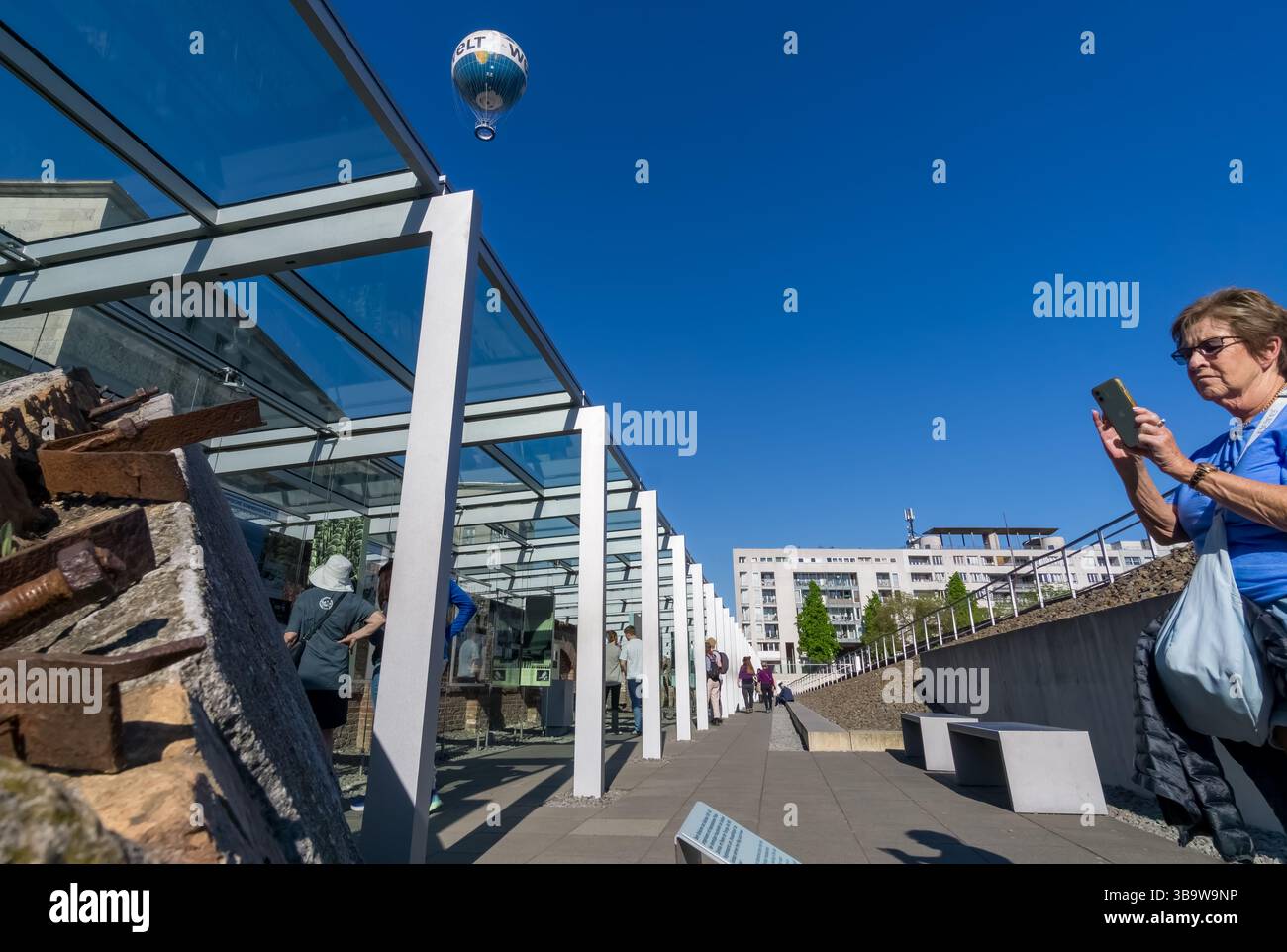 Una donna anziana turistica scatta foto di detriti storici esposti al Topography of Terror Documentation Center di Berlino, Germania. Foto Stock