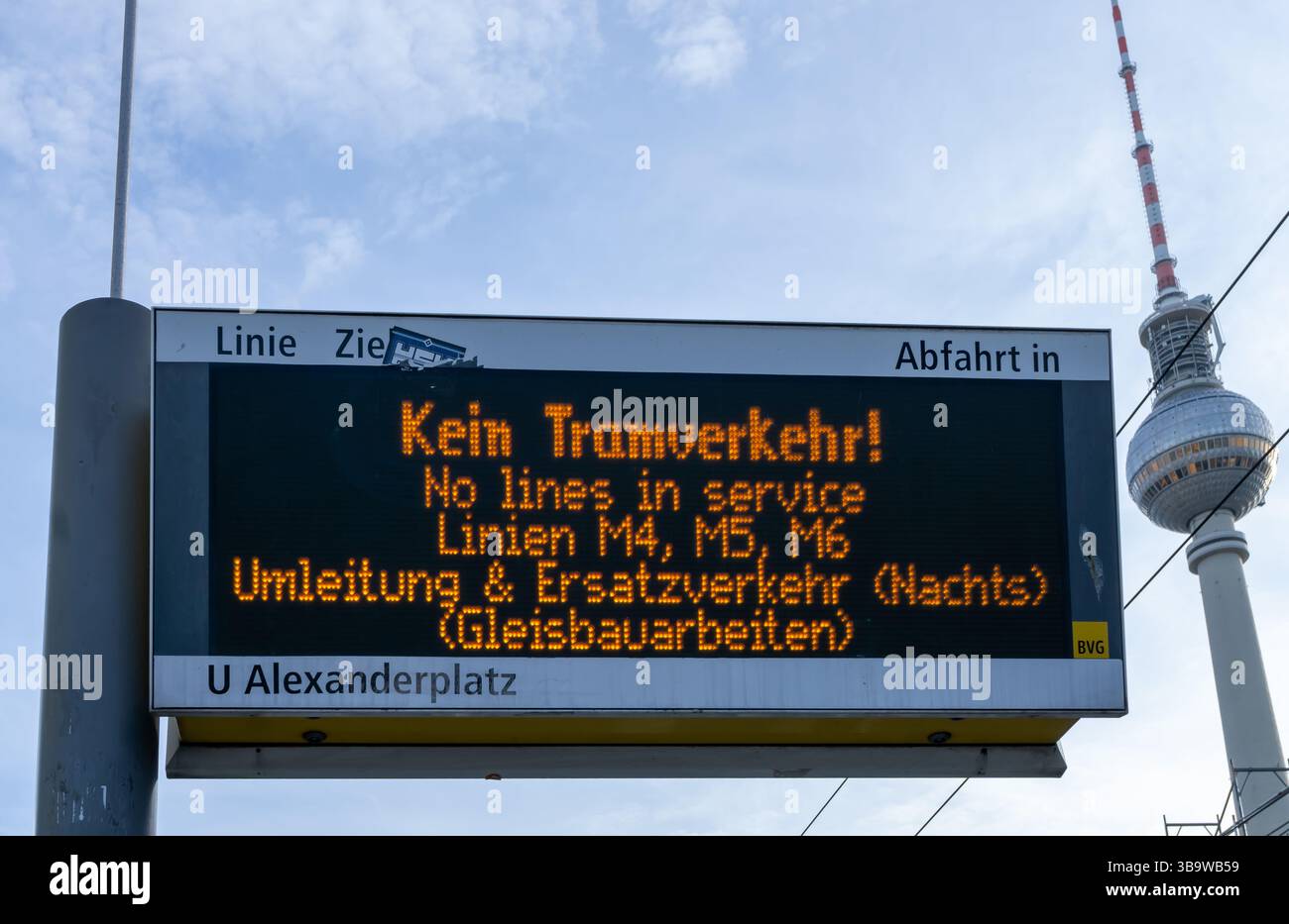 L'esposizione digitale all'Alexanderplatz Berlin annuncia un'interruzione del servizio tram vicino all'iconica torre della televisione durante i lavori di costruzione. Foto Stock