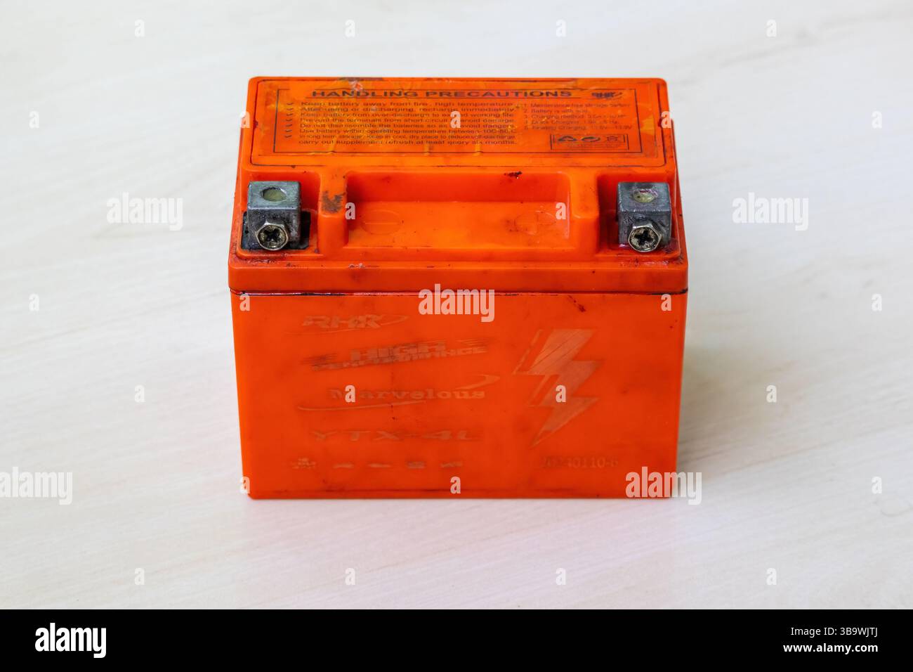 Una vecchia batteria per motociclette esente da manutenzione. Questa batteria contiene piombo, acido solforico e altre sostanze chimiche tossiche che rappresentano l'ambiente Foto Stock