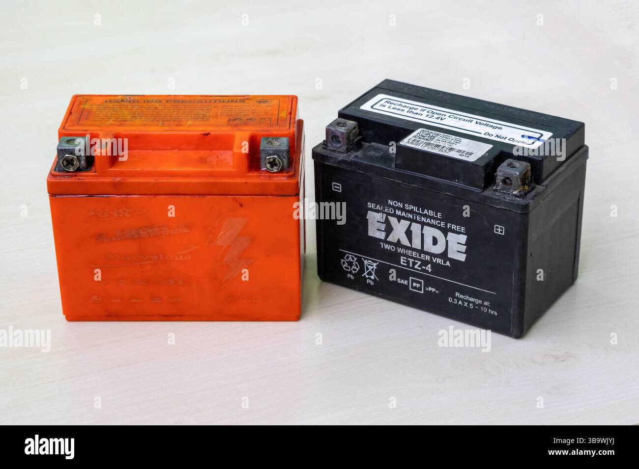 Batteria per motociclette usata e vecchia, esente da manutenzione, nera e rossa. Questa batteria contiene piombo, acido solforico e altre sostanze chimiche tossiche Foto Stock