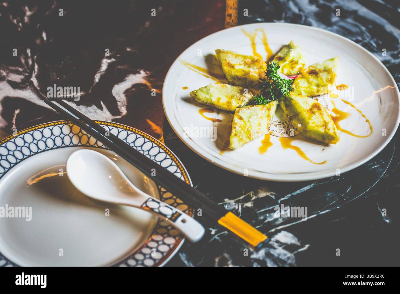 Brinjal fritto croccante glassato con una salsa Bing Chuan dolce e salata, bordi caramellati, tenero centro e un audace calcio ispirato al Sichuan Foto Stock