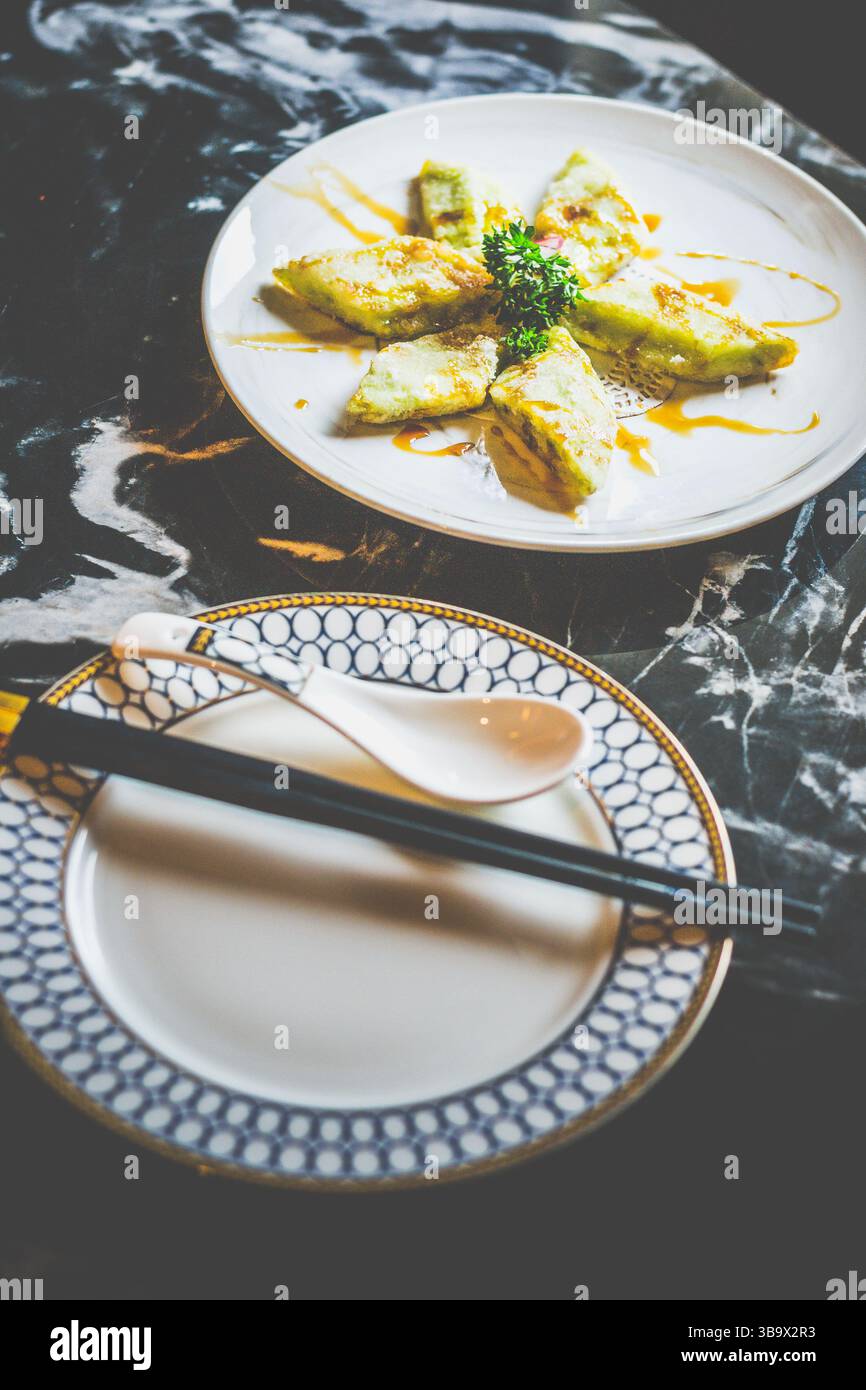 Brinjal fritto croccante glassato con una salsa Bing Chuan dolce e salata, bordi caramellati, tenero centro e un audace calcio ispirato al Sichuan Foto Stock
