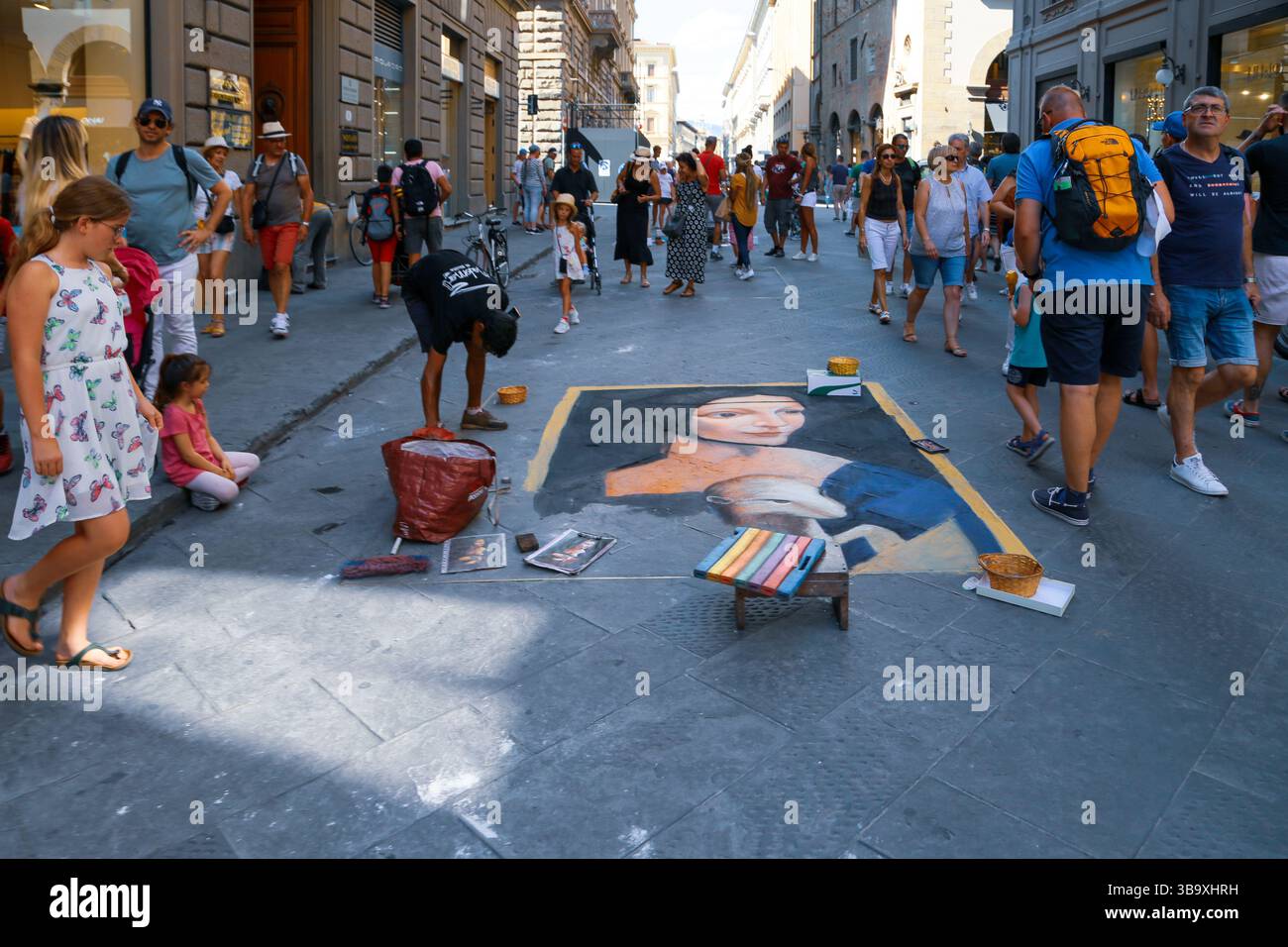 Artista di strada che crea una riproduzione gesso di famosi dipinti su una trafficata strada pedonale Foto Stock
