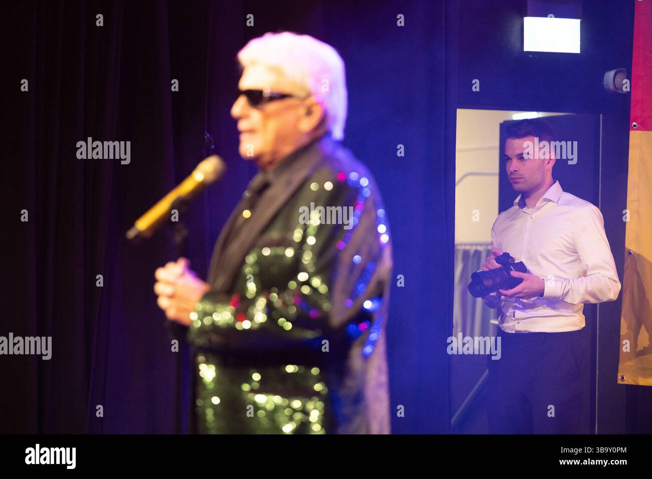 Coswig, Germania. 10 maggio 2025. Benedict Bartsch (r), social media manager, si erge dietro la star della musica pop e folk Heino sul palco durante un concerto del tour "Made in Germany" alla Borsa di Coswig. Crediti: Sebastian Kahnert/dpa/Alamy Live News Foto Stock