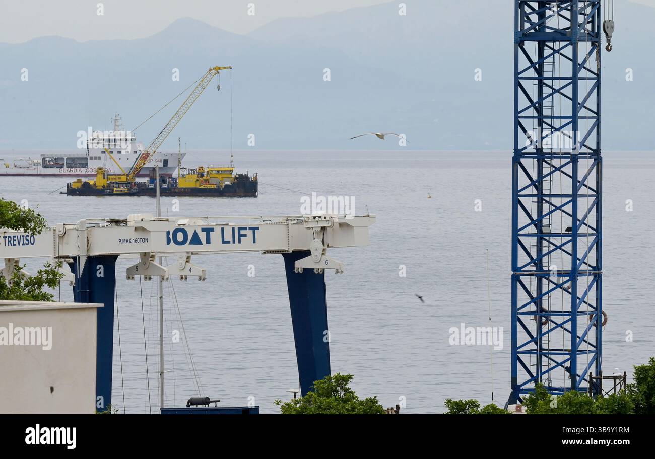 ITALIA, Sicilia, baia e porto di Porticello, nave della guardia costiera italiana e gru olandese Hebo Lift 2 per il salvataggio della nave dello yacht bayesiano / Bucht von Porticello auf Sizilien, das holländische Kranschiff Hebo Lift 2 soll das Wrack der Segelyacht Bayesian zur Klärung des Unglücks bergen, Die Segelyacht ist hier am 19. Agosto 2024 gesunken, bei Unglück kamen sieben Menschen ums Leben kamen – Darunter Mike Lynch, der britische Unternehmer software Milliardär und Gründer von Autonomy, Seine Tochter Hannah, das Ehepaar Jonathan und Judy Bloomer, Chris und Neda Morvillo sowie der Bordkoch Recaldo Tho Foto Stock