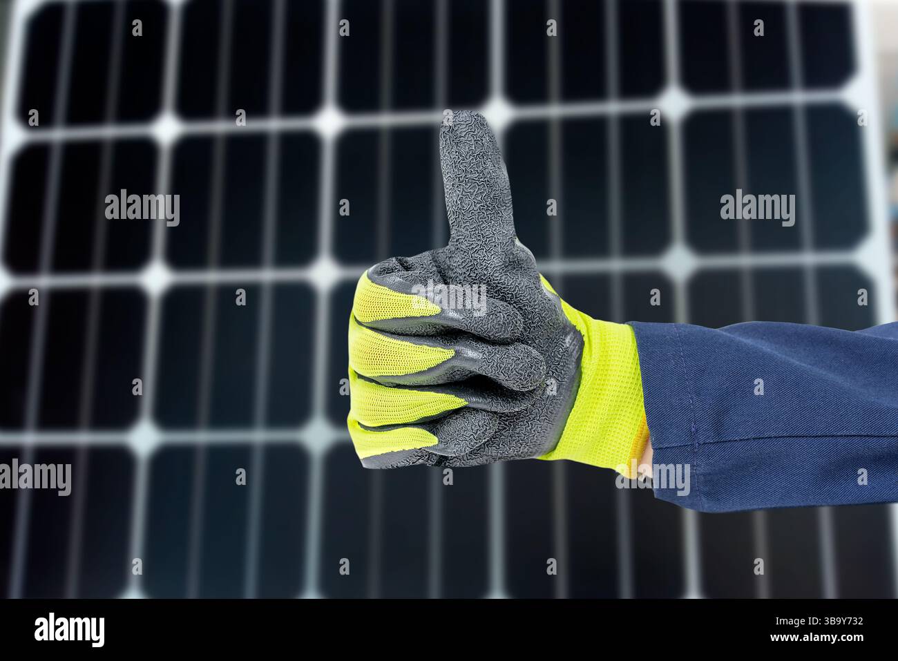 Foto di un tuttofare che gestiva il pollice con guanto giallo e nero scuro con sfondo del pannello solare. Produzione di energia elettrica per le proprie esigenze e per il proprio Foto Stock