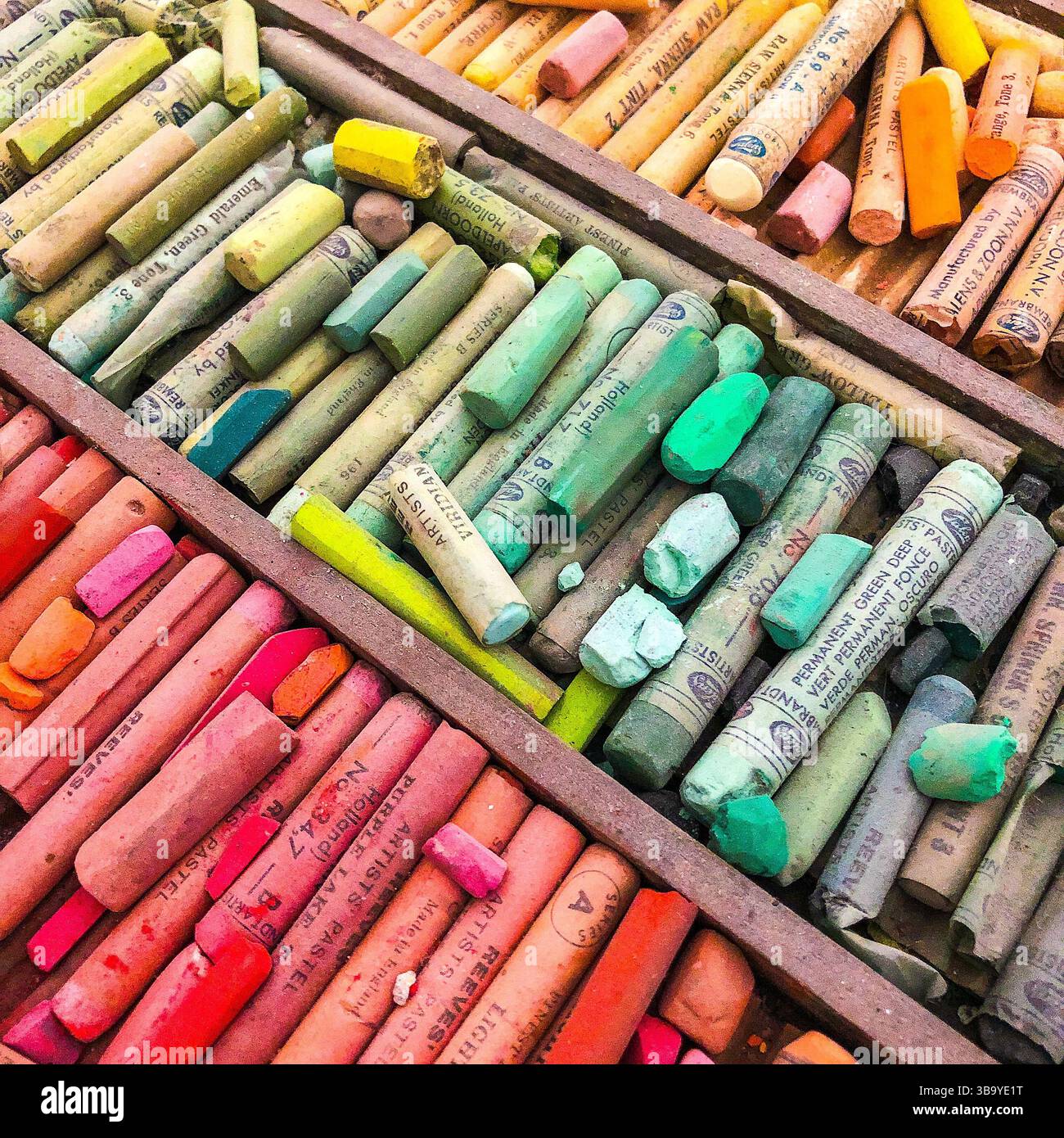 Colori assortiti e sfumature di giallo, verde e rosso dei pastelli pastello dell'artista. Foto Stock