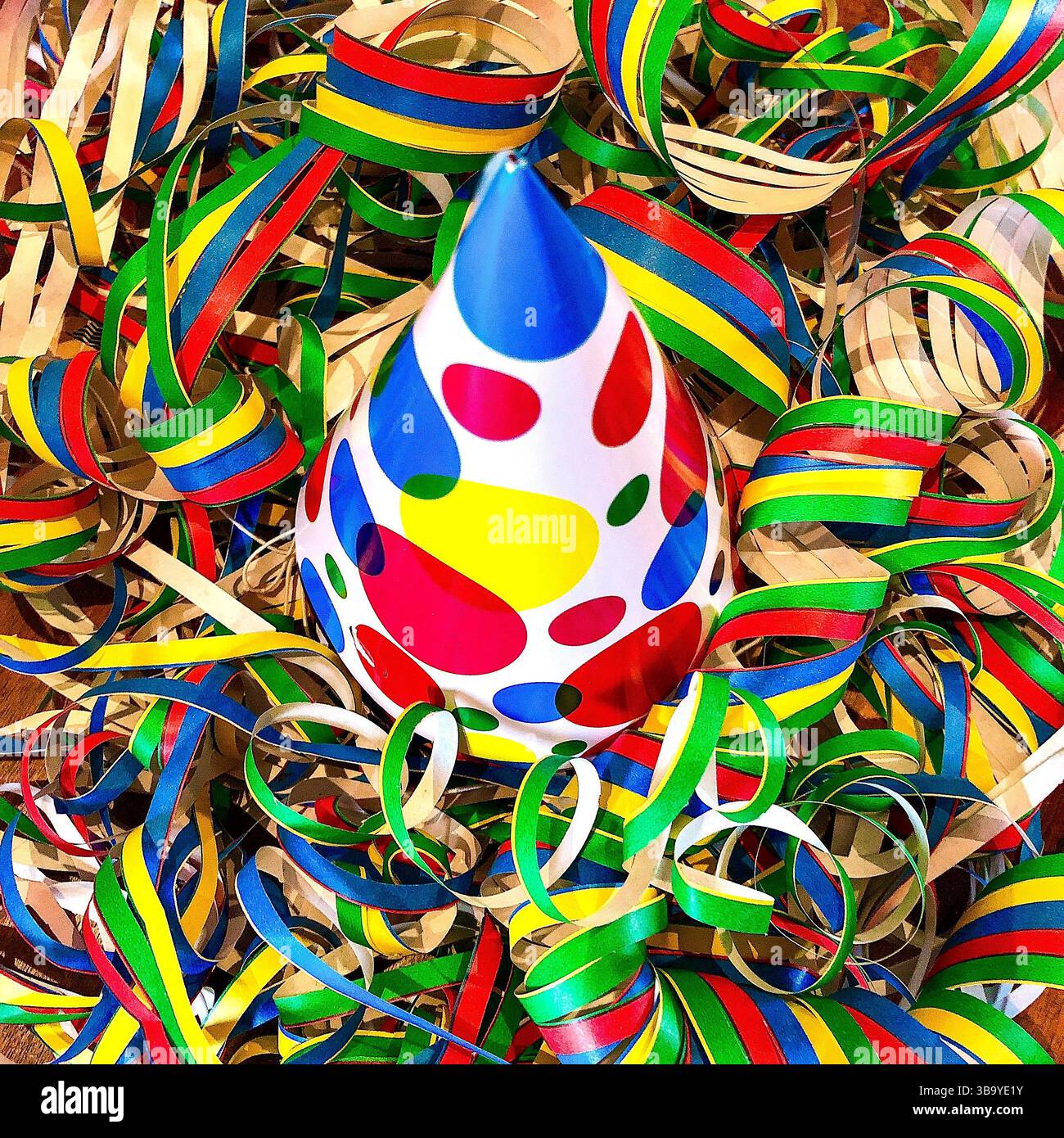 Cappello decorativo conico in carta da festa con tanti streamer colorati... Dopo i festeggiamenti di Capodanno. Foto Stock