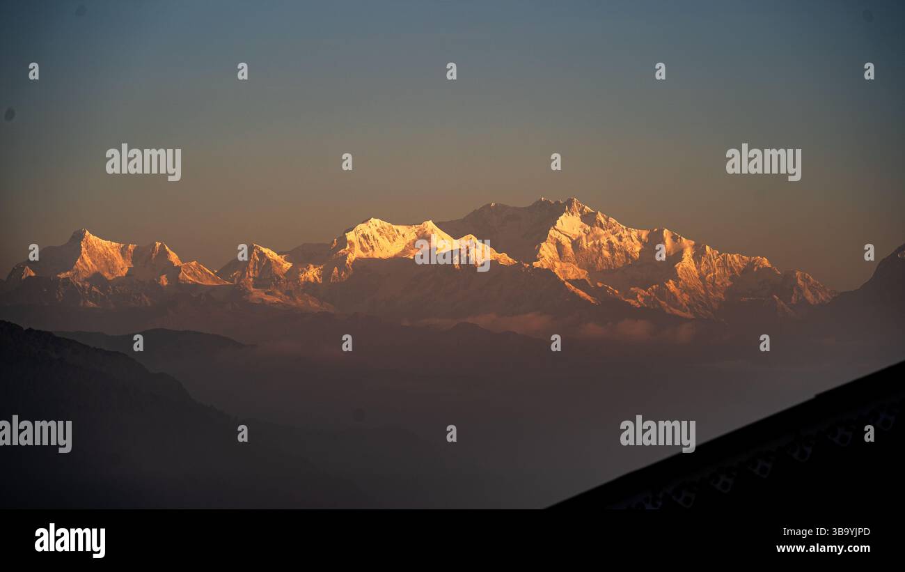 Alba dorata sul Monte La catena dei Kanchenjungha si vede da Singhik, Sikkim, inondata dalla luce soffusa e dorata del sole, le maestose cime brillano nel sereno silenzio mattutino Foto Stock