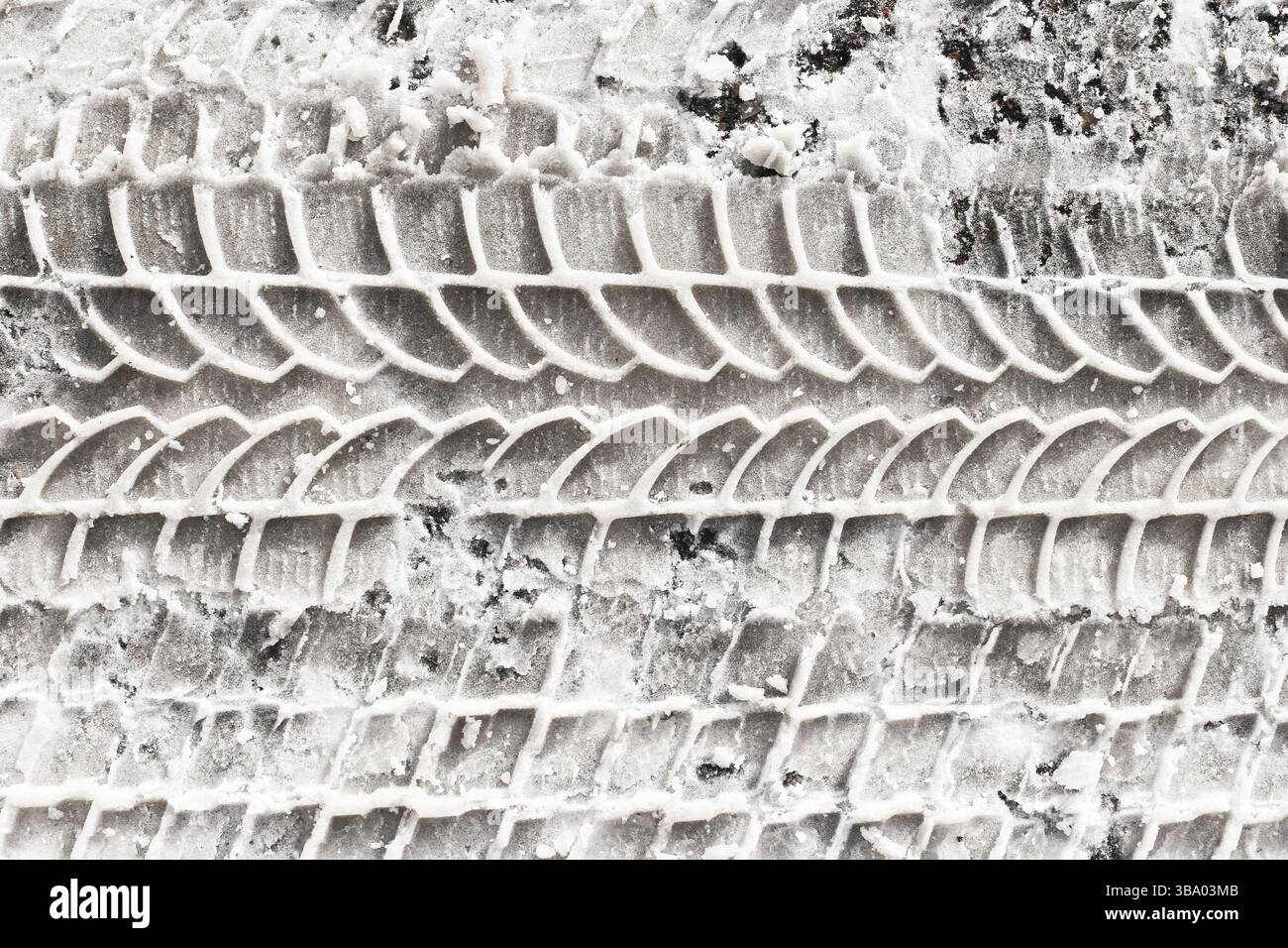 Battistrada nella neve. Ingombro del veicolo invernale. Struttura della ruota dell'auto su superficie bianca. Contrassegno del terreno ghiacciato. Battistrada in gomma ruvida. Strada a basse temperature. Foto Stock