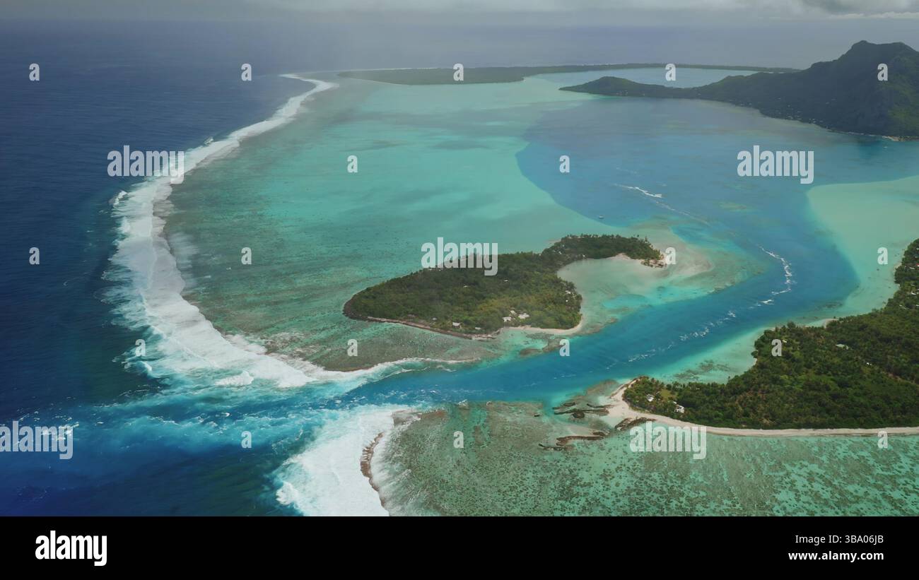 Splendida vista aerea che cattura huahine, Polinesia francese, con lussureggianti isole tropicali circondate da vibranti barriere coralline e acque turchesi cristalline Foto Stock