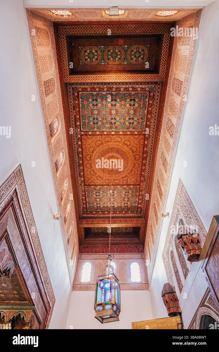 6 marzo 2025, Marrakech, Marocco: Intricate sculture in legno e una lampada a vetrate appesa al soffitto del Palazzo Bahia Foto Stock