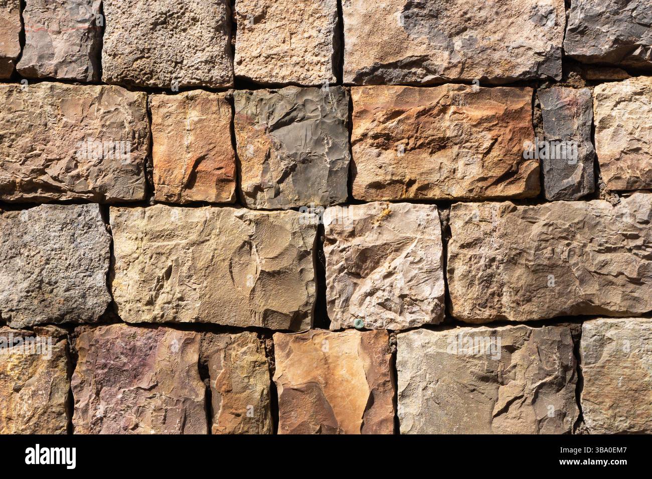Struttura delle pareti in pietra naturale. Schema rustico di rocce. Superficie in pietra marrone e beige. Vecchia costruzione in muratura. Materiale da costruzione ruvido. Foto Stock