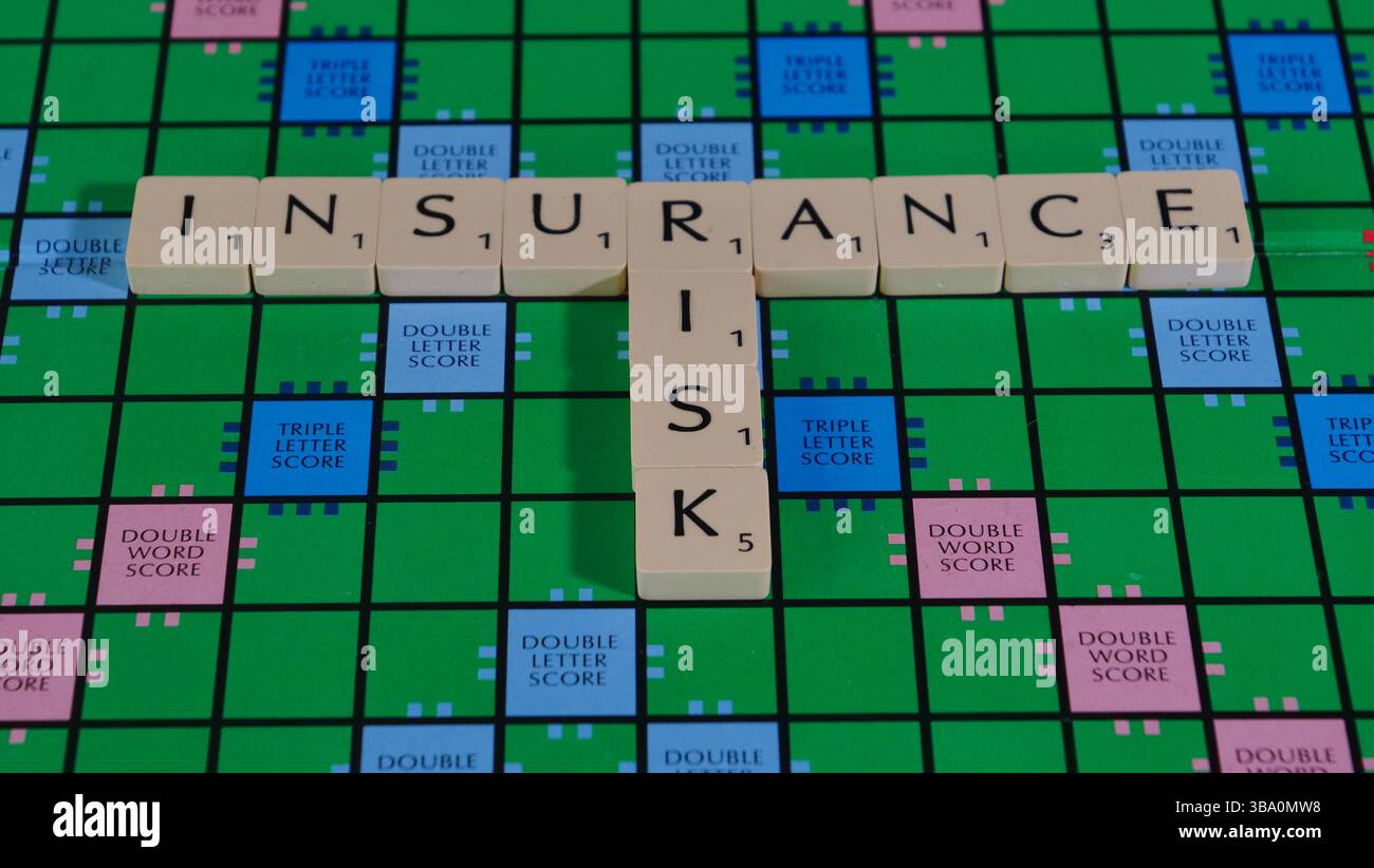Le parole rischio assicurativo sono riportate su una lavagna di valutazione per illustrare il concetto di rischio. Foto Stock