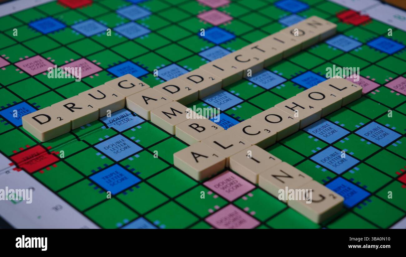 Il concetto di dipendenza è illustrato su una lavagna di Scrabble con le parole droga, gioco d'azzardo, alcol, dipendenza, scritto. Foto Stock