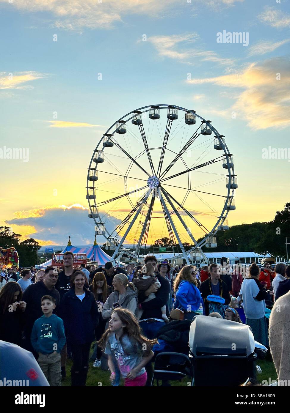 Ruota panoramica e folla di festival al tramonto durante la Cheshire Balloon Fiesta a Bolesworth Estate, Tattenhall, Regno Unito, il 6 agosto 2023. Foto Stock