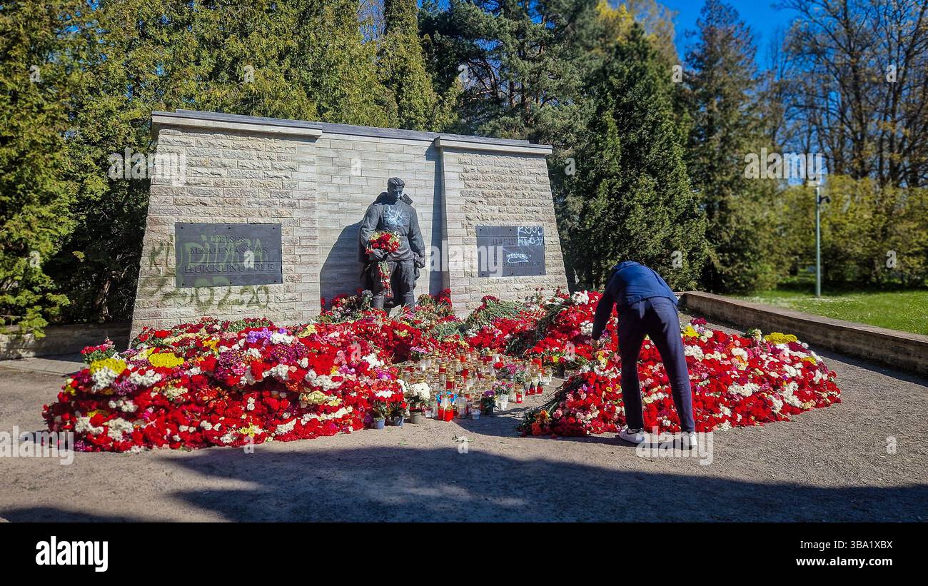 Controverso memoriale di guerra sovietico della seconda guerra mondiale a Tallinn. Il 9 maggio, molti russi etnici in Estonia, commemorano il giorno della Vittoria portando fiori rossi. - Immagine stock catturata con smartphone
