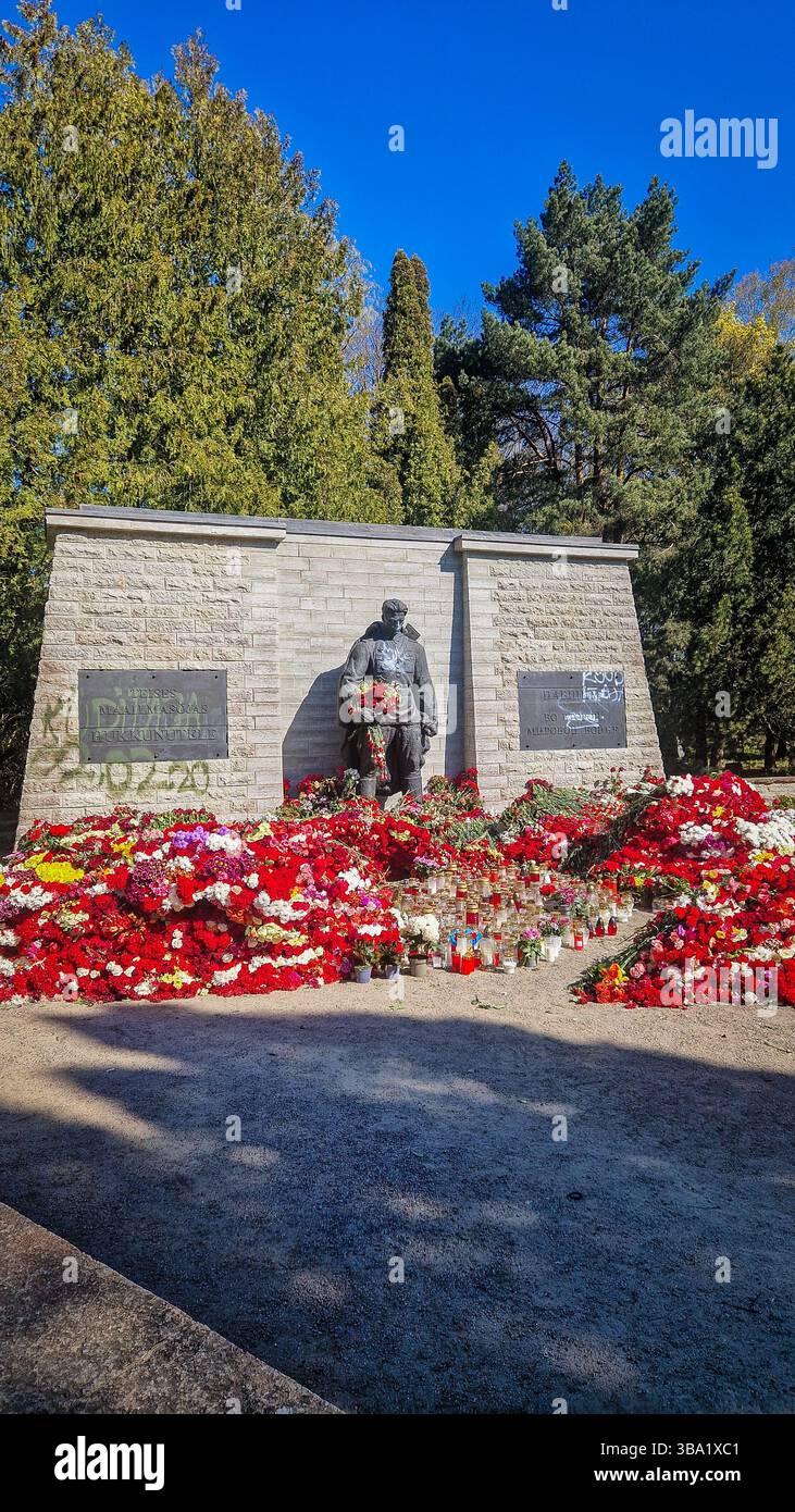 Controverso memoriale di guerra sovietico della seconda guerra mondiale a Tallinn. Il 9 maggio, molti russi etnici in Estonia, commemorano il giorno della Vittoria portando fiori rossi. - Immagine stock catturata con smartphone