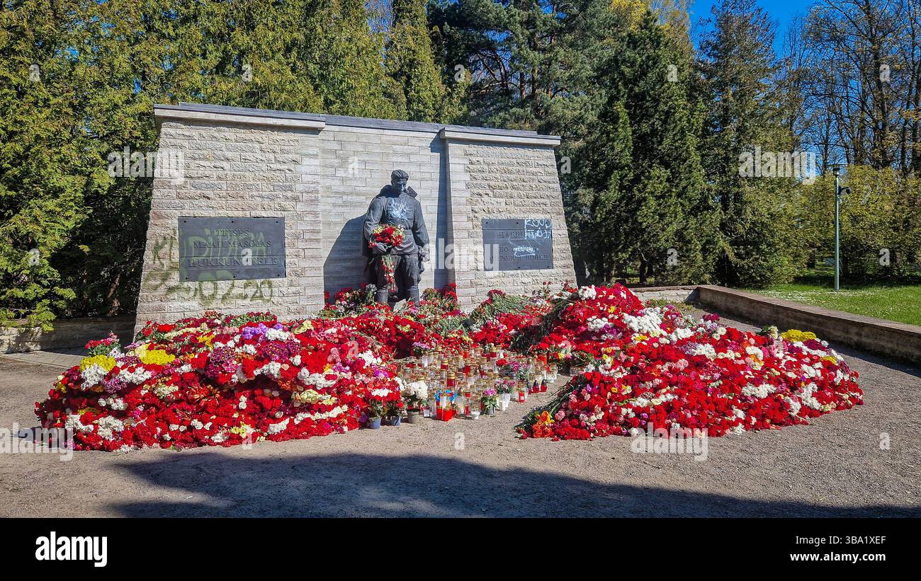 Controverso memoriale di guerra sovietico della seconda guerra mondiale a Tallinn. Il 9 maggio, molti russi etnici in Estonia, commemorano il giorno della Vittoria portando fiori rossi. - Immagine stock catturata con smartphone