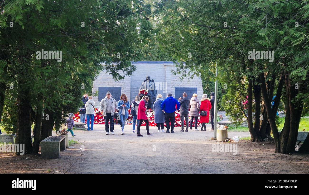 Controverso memoriale di guerra sovietico della seconda guerra mondiale a Tallinn. Il 9 maggio, molti russi etnici in Estonia, commemorano il giorno della Vittoria portando fiori rossi. - Immagine stock catturata con smartphone